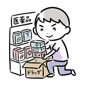 ドラッグと書かれた段ボール箱から風邪薬や医薬品を取り出して陳列棚に補充する男性スタッフ