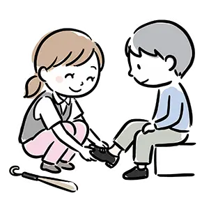 腰をかがめて男の子の靴を優しく履かせてサイズ合わせをする靴屋の女性販売員